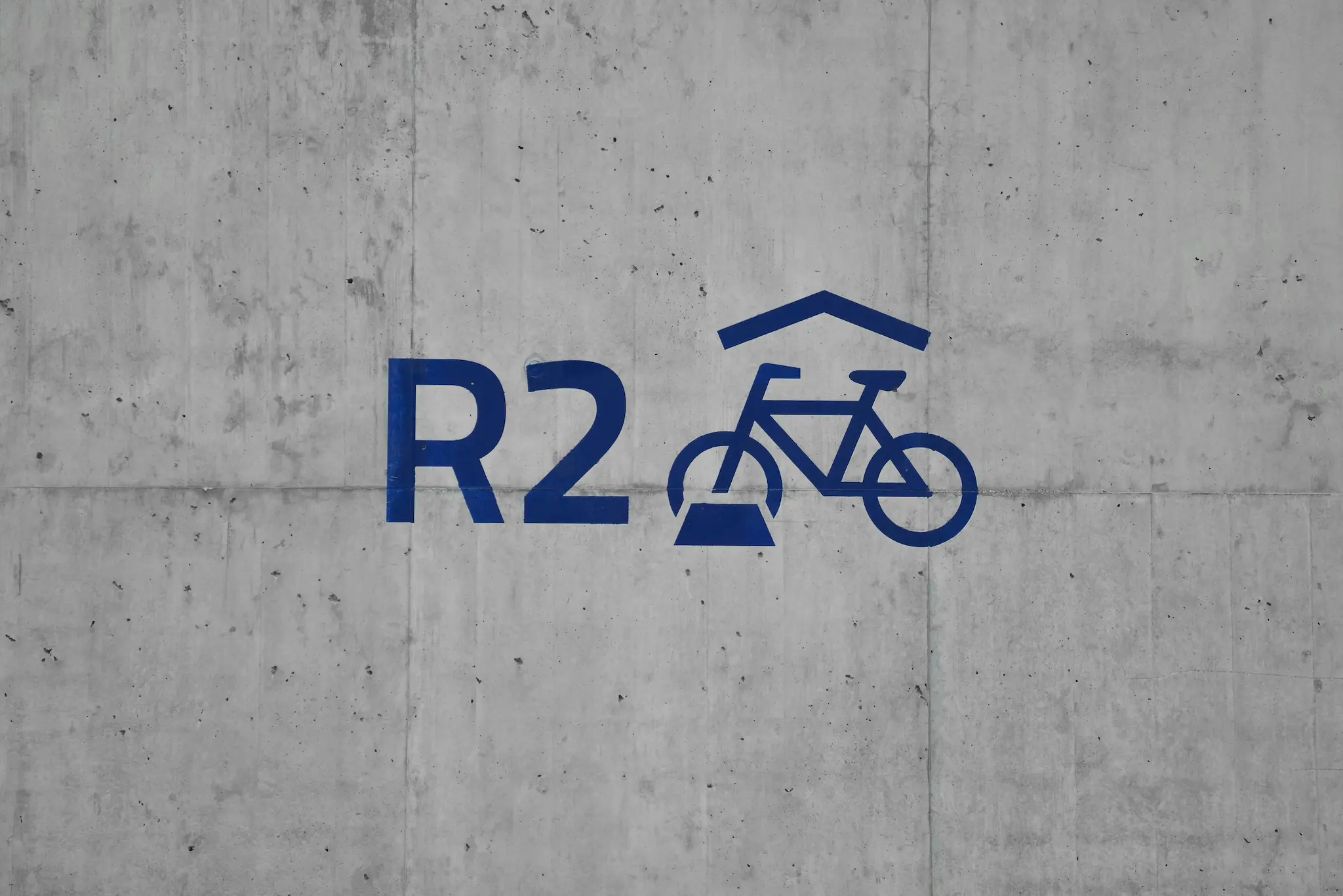 Logo « R2 » et pictogramme de vélo imprimés sur un mur en béton